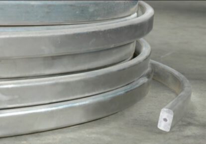 Coiled metal corrosion protection strip on concrete floor at BK Corrosion.